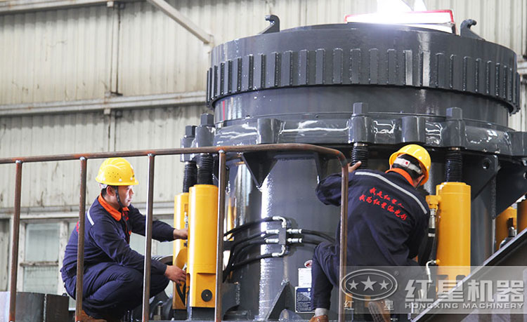 工作人員檢測圓錐破碎機(jī)，保障生產(chǎn)的設(shè)備都有高質(zhì)量